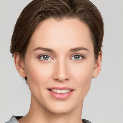 Joyful white young-adult female with short  brown hair and grey eyes