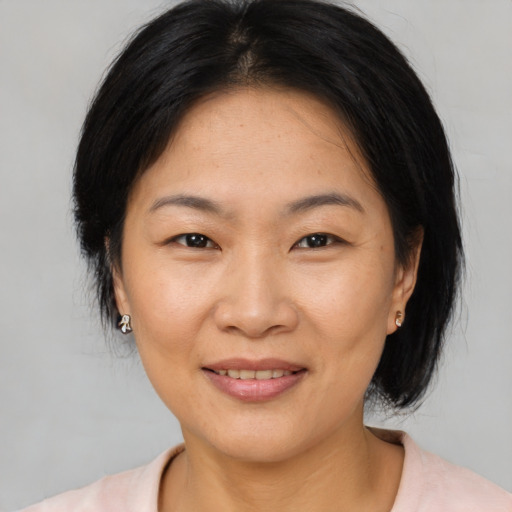 Joyful asian adult female with medium  brown hair and brown eyes