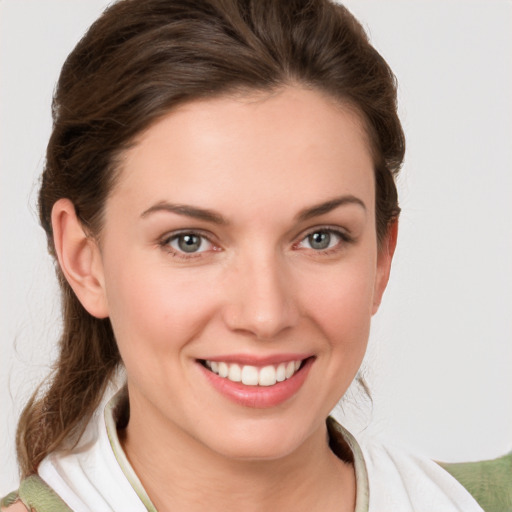 Joyful white young-adult female with medium  brown hair and grey eyes