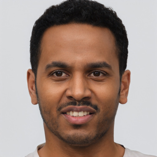 Joyful black young-adult male with short  black hair and brown eyes
