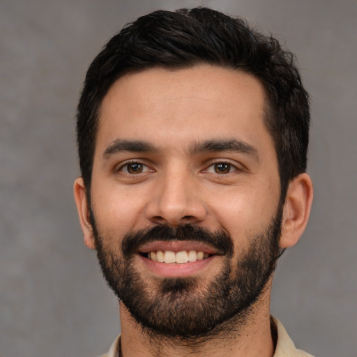 Joyful white young-adult male with short  black hair and brown eyes