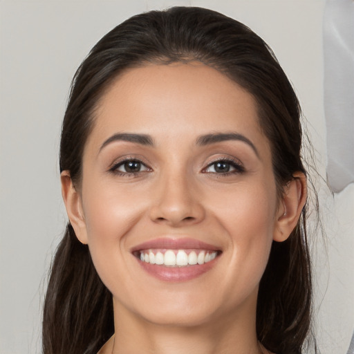 Joyful white young-adult female with long  brown hair and brown eyes