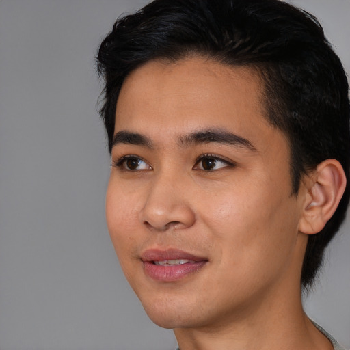 Joyful asian young-adult male with short  black hair and brown eyes