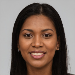 Joyful black young-adult female with long  brown hair and brown eyes