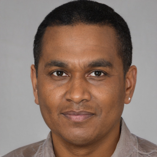Joyful latino adult male with short  black hair and brown eyes