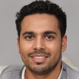 Joyful white young-adult male with short  black hair and brown eyes