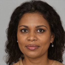 Joyful black adult female with long  brown hair and brown eyes