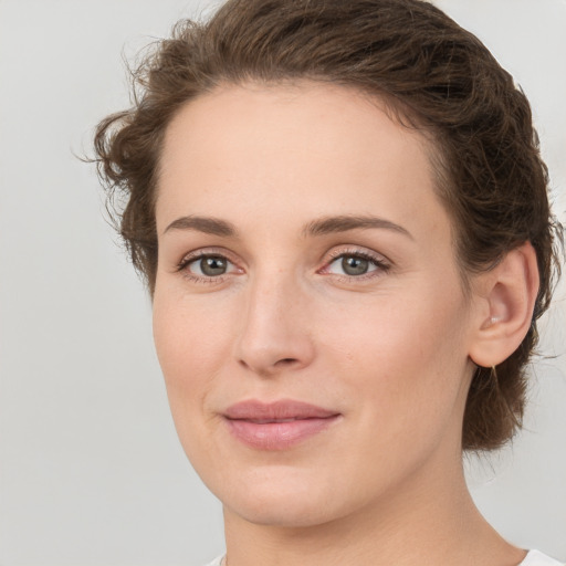 Joyful white young-adult female with medium  brown hair and green eyes