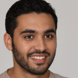 Joyful latino young-adult male with short  black hair and brown eyes