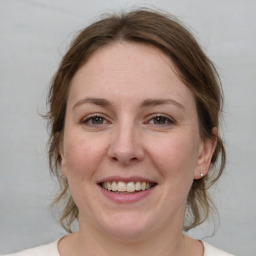 Joyful white young-adult female with medium  brown hair and grey eyes