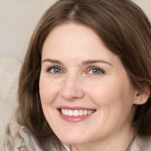 Joyful white young-adult female with medium  brown hair and grey eyes