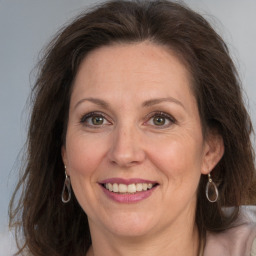 Joyful white adult female with long  brown hair and grey eyes