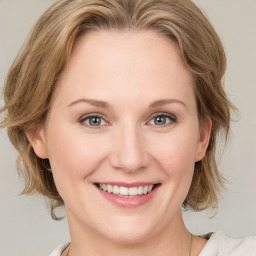 Joyful white young-adult female with medium  brown hair and blue eyes