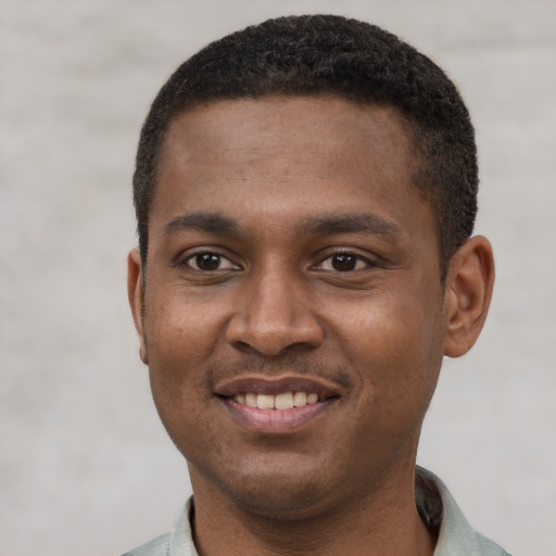 Joyful black young-adult male with short  black hair and brown eyes