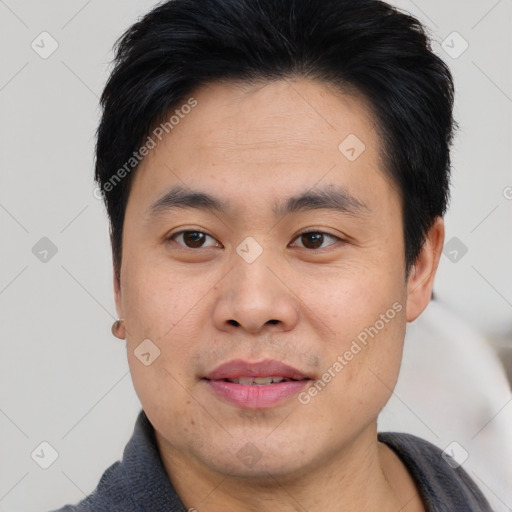 Joyful asian young-adult male with short  brown hair and brown eyes