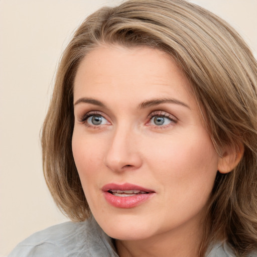 Joyful white young-adult female with medium  brown hair and blue eyes