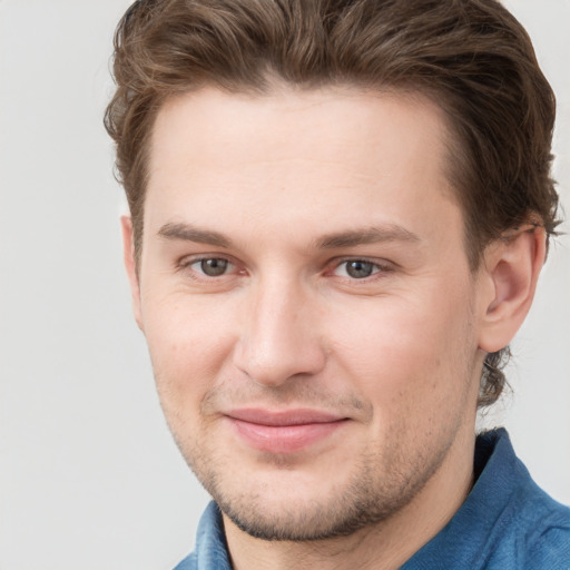 Joyful white young-adult male with short  brown hair and grey eyes