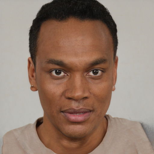 Joyful black young-adult male with short  black hair and brown eyes
