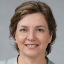 Joyful white adult female with medium  brown hair and grey eyes