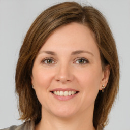 Joyful white young-adult female with medium  brown hair and green eyes