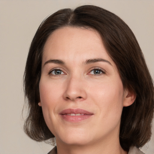 Joyful white adult female with medium  brown hair and brown eyes