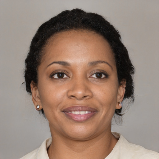 Joyful black adult female with medium  brown hair and brown eyes