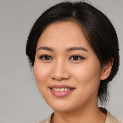 Joyful asian young-adult female with medium  brown hair and brown eyes