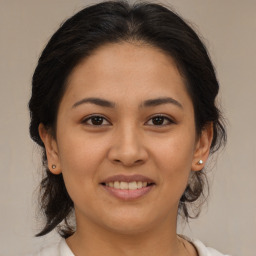 Joyful latino young-adult female with medium  brown hair and brown eyes