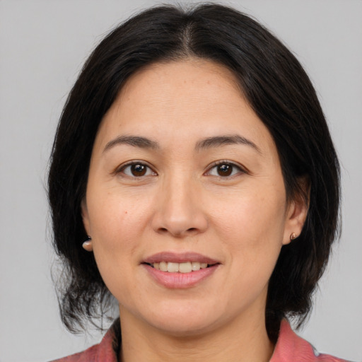 Joyful asian adult female with medium  brown hair and brown eyes