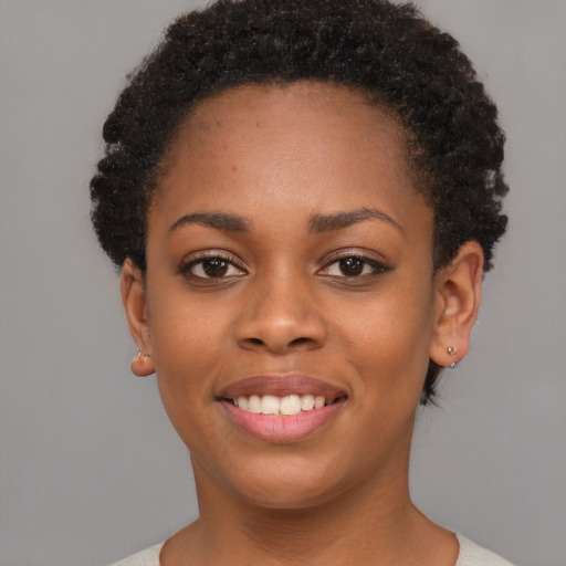 Joyful black young-adult female with short  brown hair and brown eyes