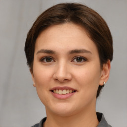 Joyful white young-adult female with short  brown hair and grey eyes