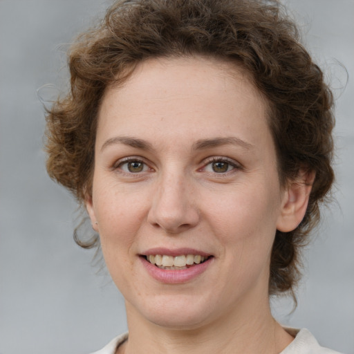 Joyful white young-adult female with medium  brown hair and green eyes