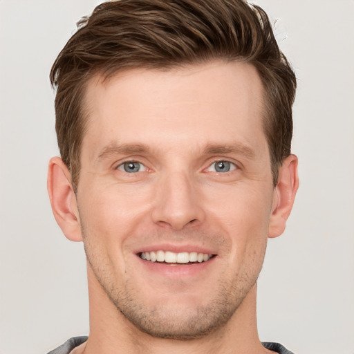 Joyful white young-adult male with short  brown hair and grey eyes