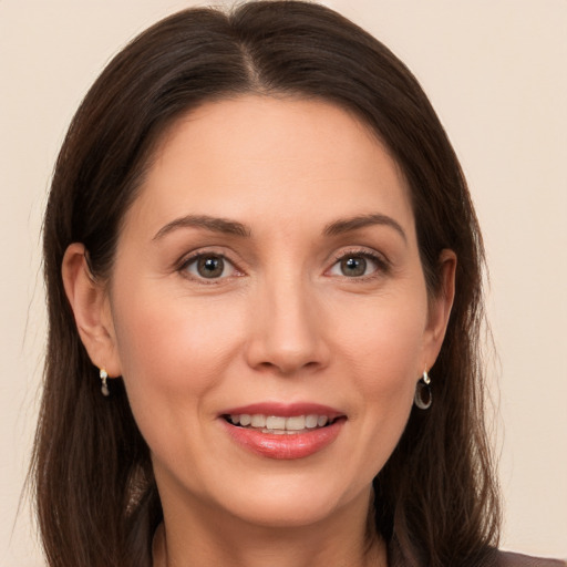 Joyful white adult female with long  brown hair and brown eyes