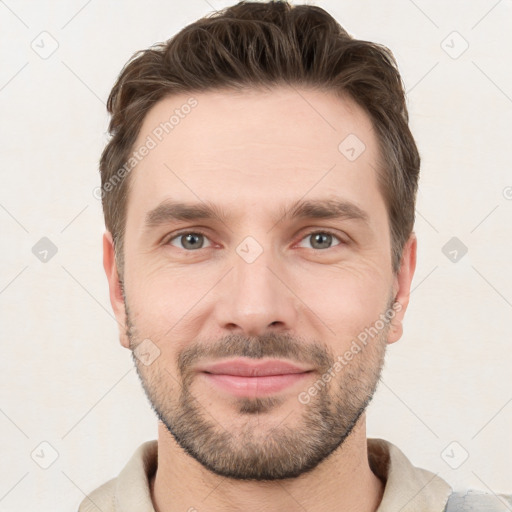 Joyful white young-adult male with short  brown hair and grey eyes