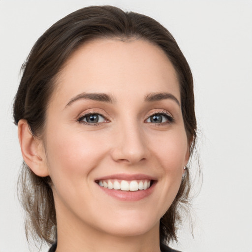 Joyful white young-adult female with medium  brown hair and grey eyes