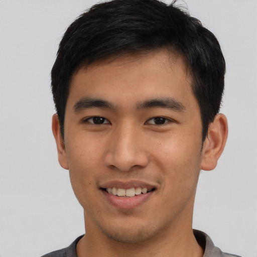 Joyful asian young-adult male with short  black hair and brown eyes