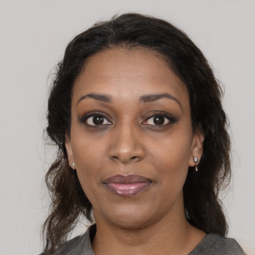 Joyful black adult female with medium  brown hair and brown eyes