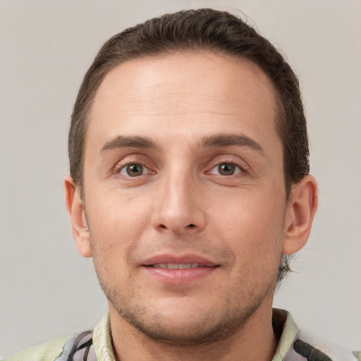 Joyful white young-adult male with short  brown hair and grey eyes