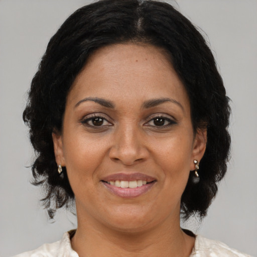 Joyful black adult female with medium  brown hair and brown eyes