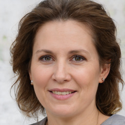 Joyful white adult female with medium  brown hair and brown eyes