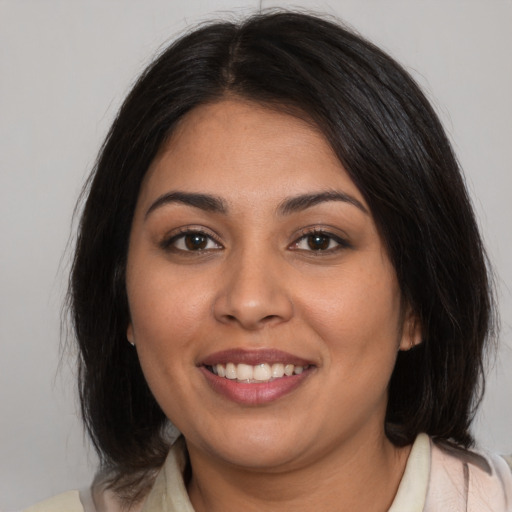 Joyful latino young-adult female with medium  brown hair and brown eyes