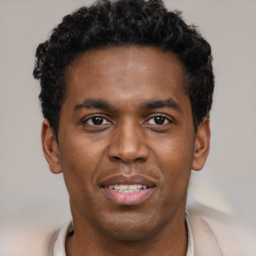 Joyful black young-adult male with short  black hair and brown eyes