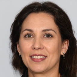 Joyful white adult female with long  brown hair and brown eyes