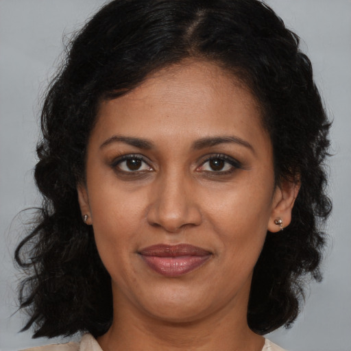 Joyful black adult female with long  brown hair and brown eyes