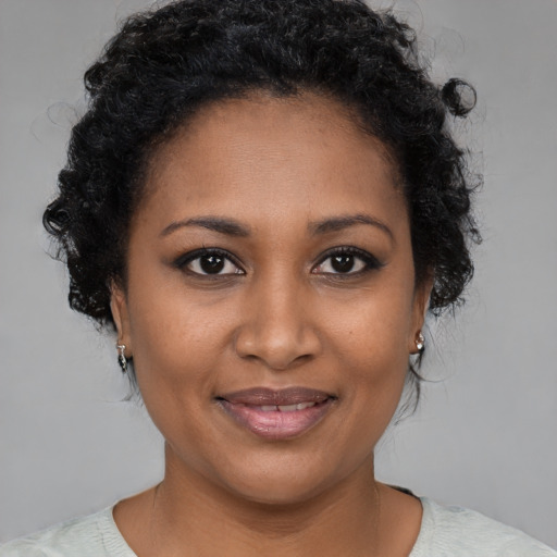 Joyful black young-adult female with short  brown hair and brown eyes