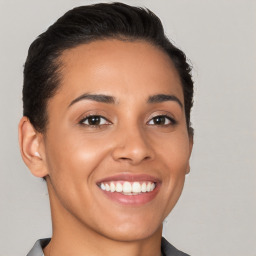 Joyful latino young-adult female with short  brown hair and brown eyes