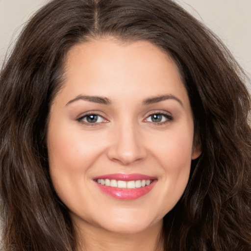 Joyful white young-adult female with long  brown hair and brown eyes