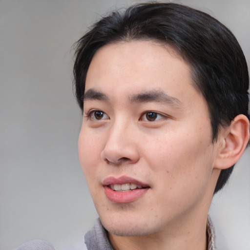 Joyful white young-adult male with medium  black hair and brown eyes