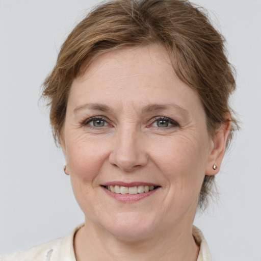 Joyful white adult female with medium  brown hair and grey eyes